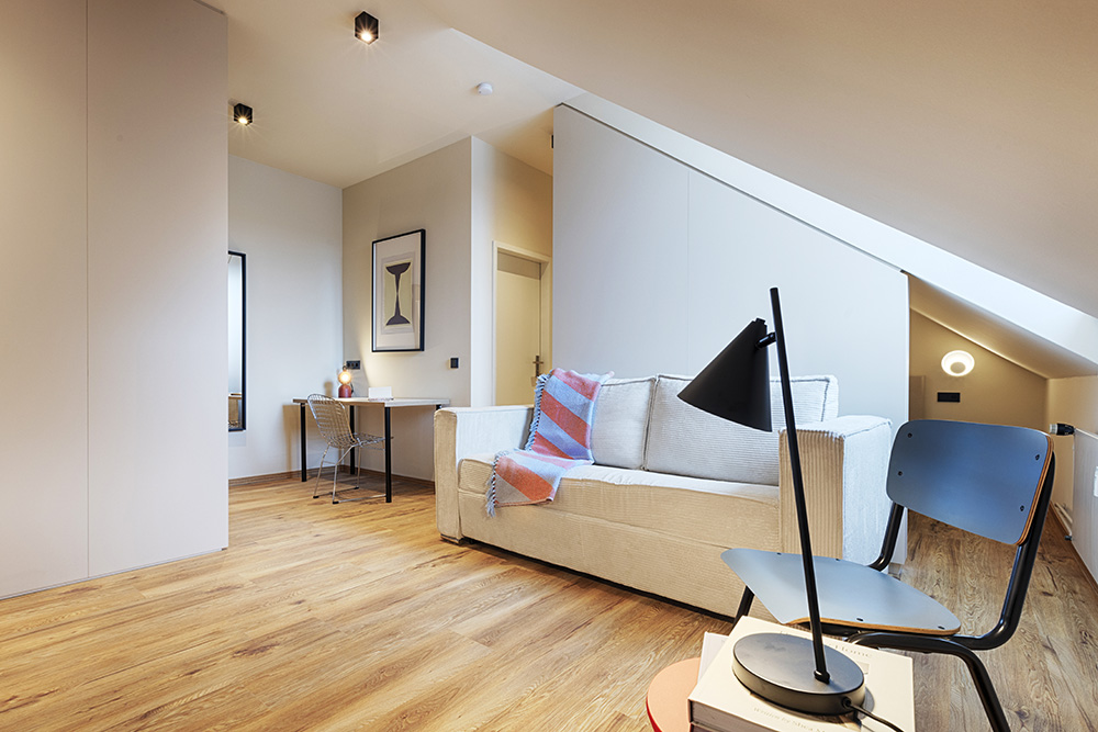 Helles Wohnzimmer einer Ferienwohnung in Würzburg mit Sofa und Fernseher