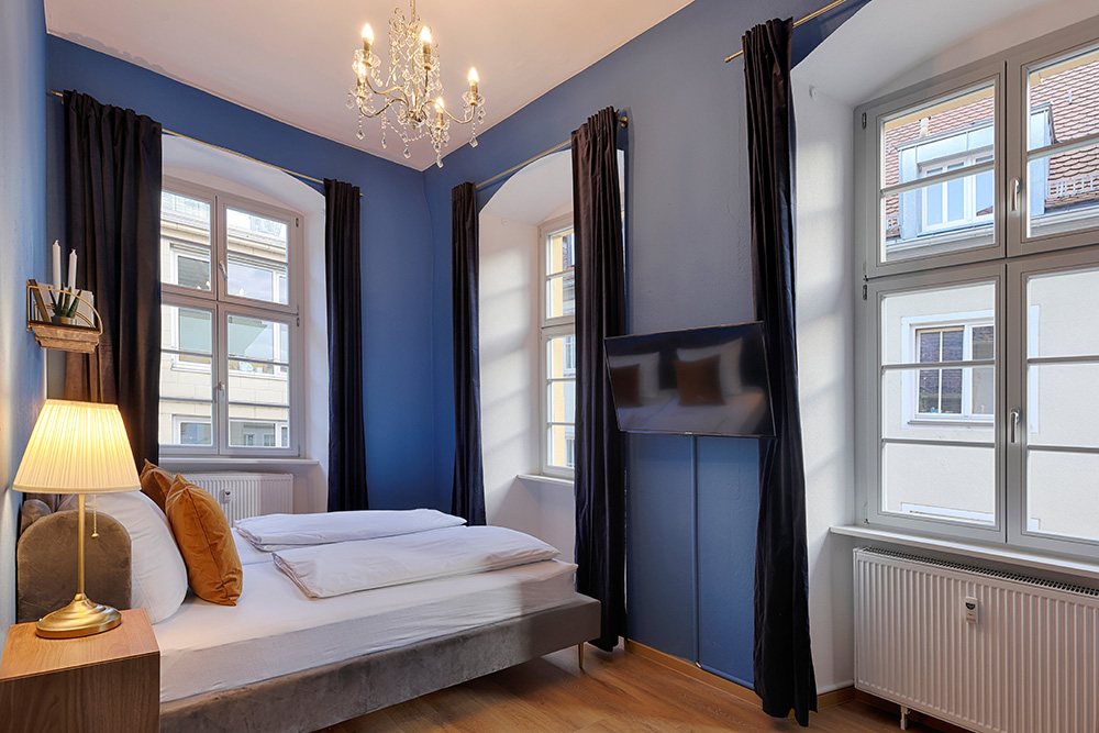 Stilvolles Schlafzimmer in einem Apartment in Würzburg mit farbiger Wand