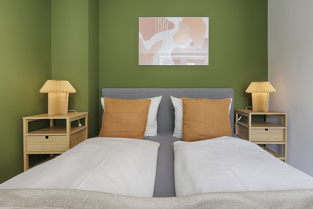 Schlafzimmer einer Ferienwohnung in Würzburg mit grünem Design
