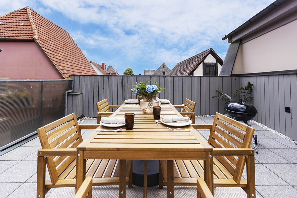 Große Terrasse einer Ferienwohnung in Würzburg mit Tisch und Sitzplätzen
